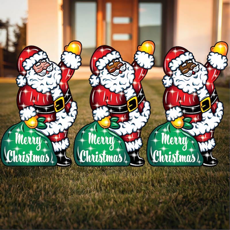 Three Santa Claus yard art figures with 'Merry Christmas' text, featuring clear lights and available in different flesh tones.