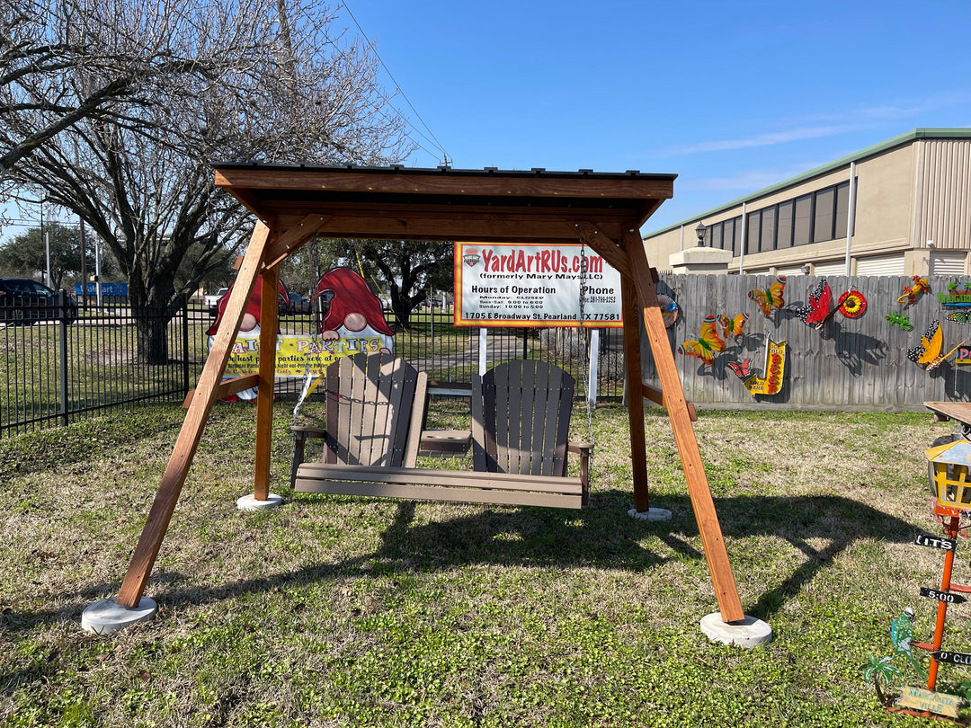 A Luxcraft poly swing with A-frame and roof, placed on grass in front of a wall with colorful art.