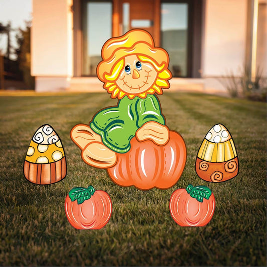 Fall Scarecrow sits on a Pumpkin Yard Sign with candy corns and pumpkins