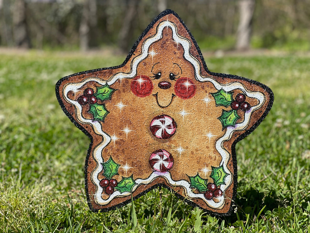 Christmas themed gingerbread star outdoor yard sign. Star features a smiley face with white "frosting" around the edges and peppermint circles for buttons. Cute Christmas yard signs with stakes are perfect for the Holiday Decorating enthusiast in your home. 