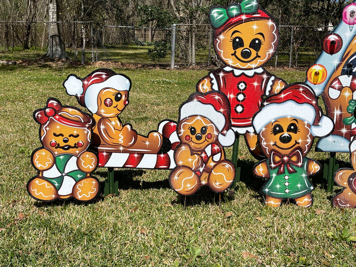 Gingerbread family outdoor Christmas Yard signs for Holiday Decorating. Featuring gingerbread dad, mom, kids and more. Each decorative lawn sign comes with stakes for easy install and placement. Set in a sparkle finish so each sign glitters under a spotlight. 