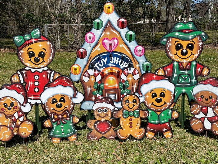 Huge 12 piece set of gingerbread characters and a gingerbread house with a sign that says "Toy Shop." These outdoor Holiday Yard signs complete any outdoor festive decor.  Set includes a gingerbread mom, dad, kids and babies. Cute, whimisical Christmas outdoor yard signs with stakes. 