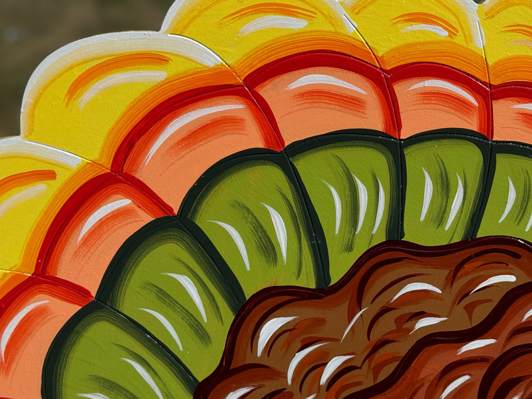 Close-up of a colorful patterned fabric with yellow, orange, red, green, and brown colors.