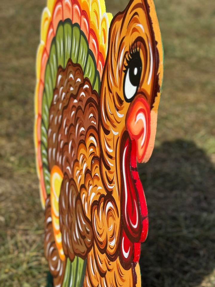 Colorful wooden turkey decoration on a grassy background