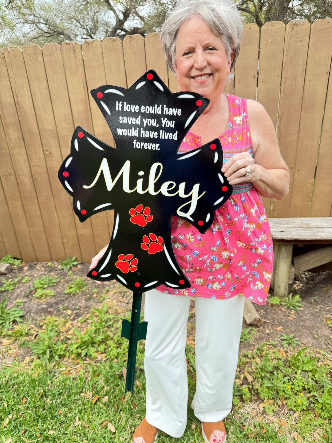 Mary, the owner of Yard Art Decor and More holding a black personalized pet memorial cross for yards, gardens, driveways, flower beds and more. Honor your beloved dog, cat, hamster, gecko or even goldfish with these beautiful, thoughtful pet memorials. 