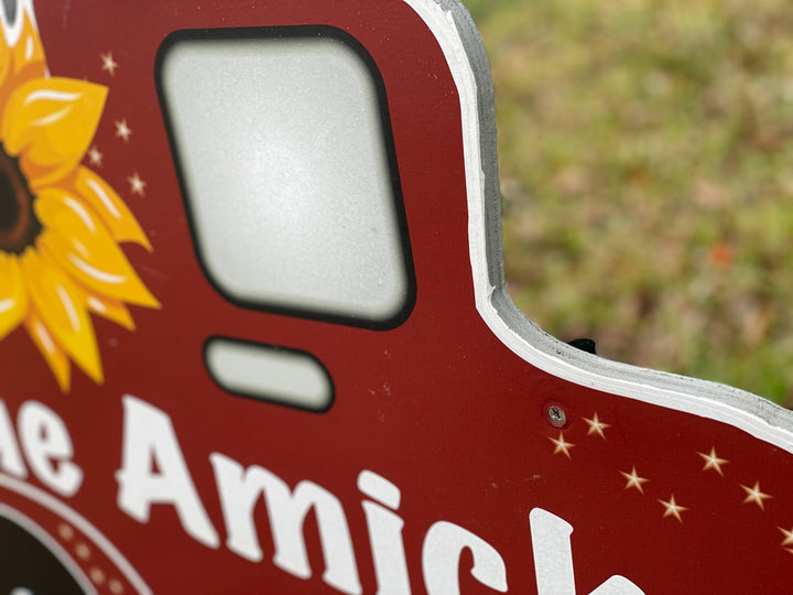 Outdoor customized yard art sign of a red pick up truck with yellow sunflowers. 