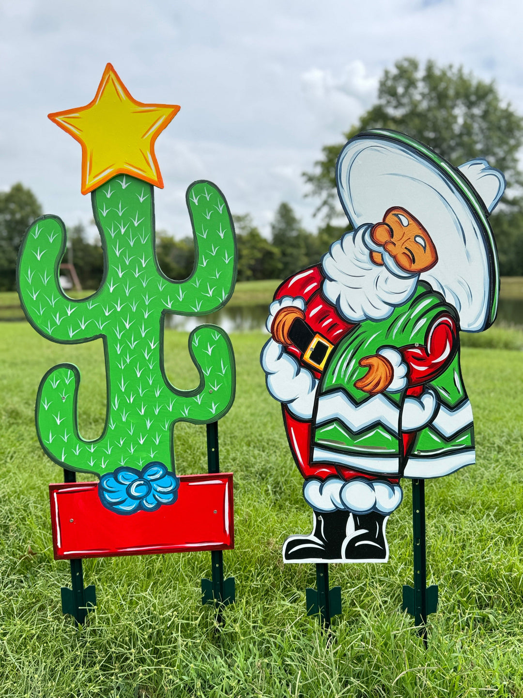 Decorative outdoor figures of a cactus and a cowboy in a grassy field.