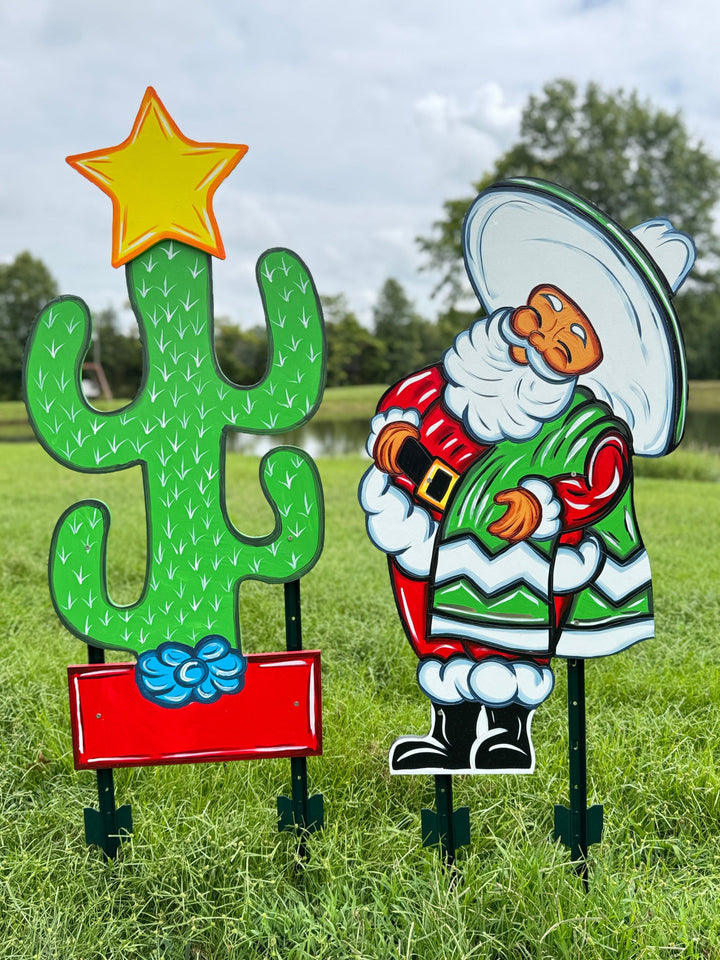 Decorative outdoor figures of a cactus and a cowboy in a grassy field.