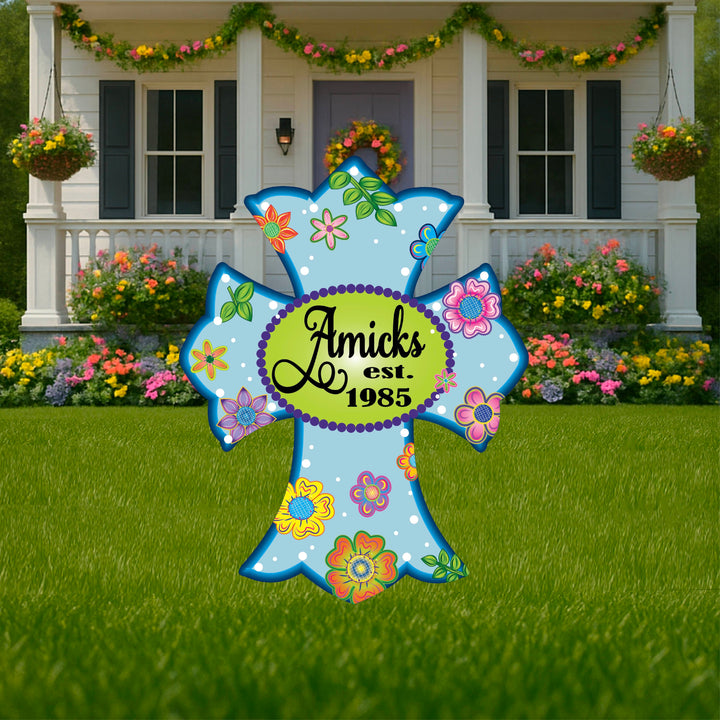 Personalized blue cross yard sign showing last name and year established. Custom cross lawn decor is perfect to celebrate and honor anniversaries, births, home purchases and more. Decorate your yard, porch, walkway, garden or porch with personalized lawn decor from Yard Art Decor and More. 
