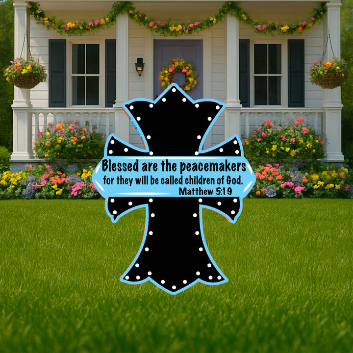 Outdoor Christian Cross Yard Sign with a black cross with blue outline. Sign quote says Blessed are the peacemakers for they wll be called children of God Mattew 5:19.  