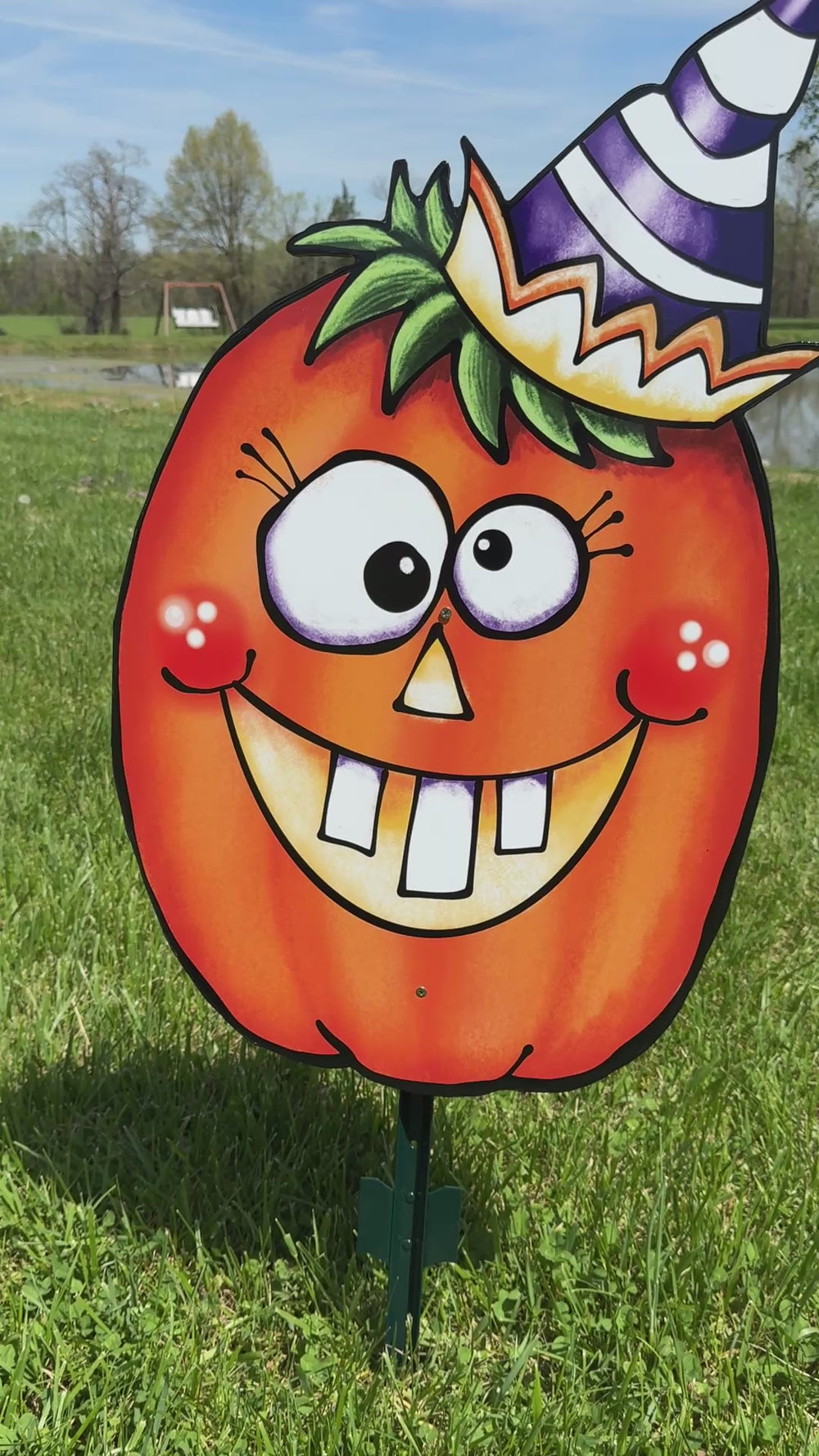 Cute, funny pumpkin Halloween yard sign for fall outdoor decorating. Pumpkin is smiling and their eyes are crossed and is wearing a blue and white cone-style party hat. 