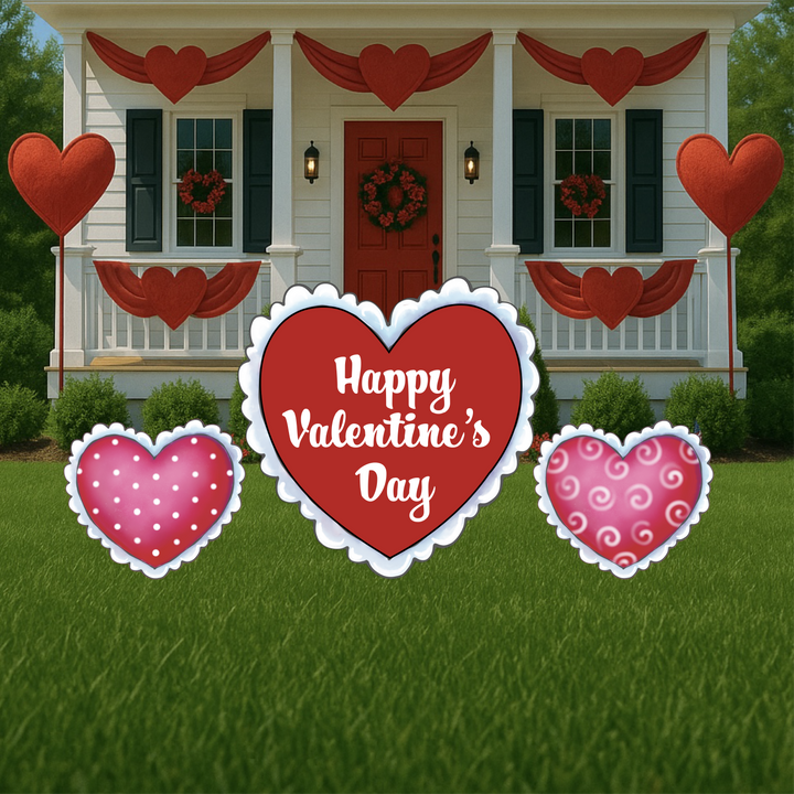 Valentine’s Day yard decorations featuring three heart-shaped signs, including a large red heart with the message "Happy Valentine’s Day," displayed in front of a home adorned with red heart bunting and festive porch decor.