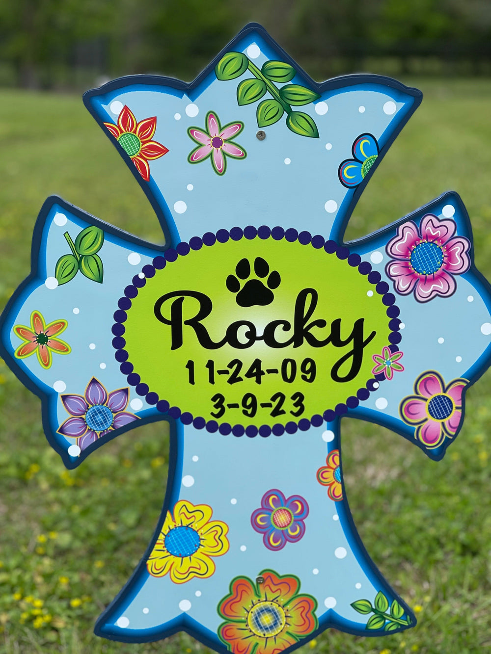Customized pet memorial decorative outdoor lawn cross in light blue with flowers. Outdoor pet crosses can be personalized with your pets name, date of birth/death, favorite quote and more. Beautiful lawn decorations to memorialize and honor your pet. 