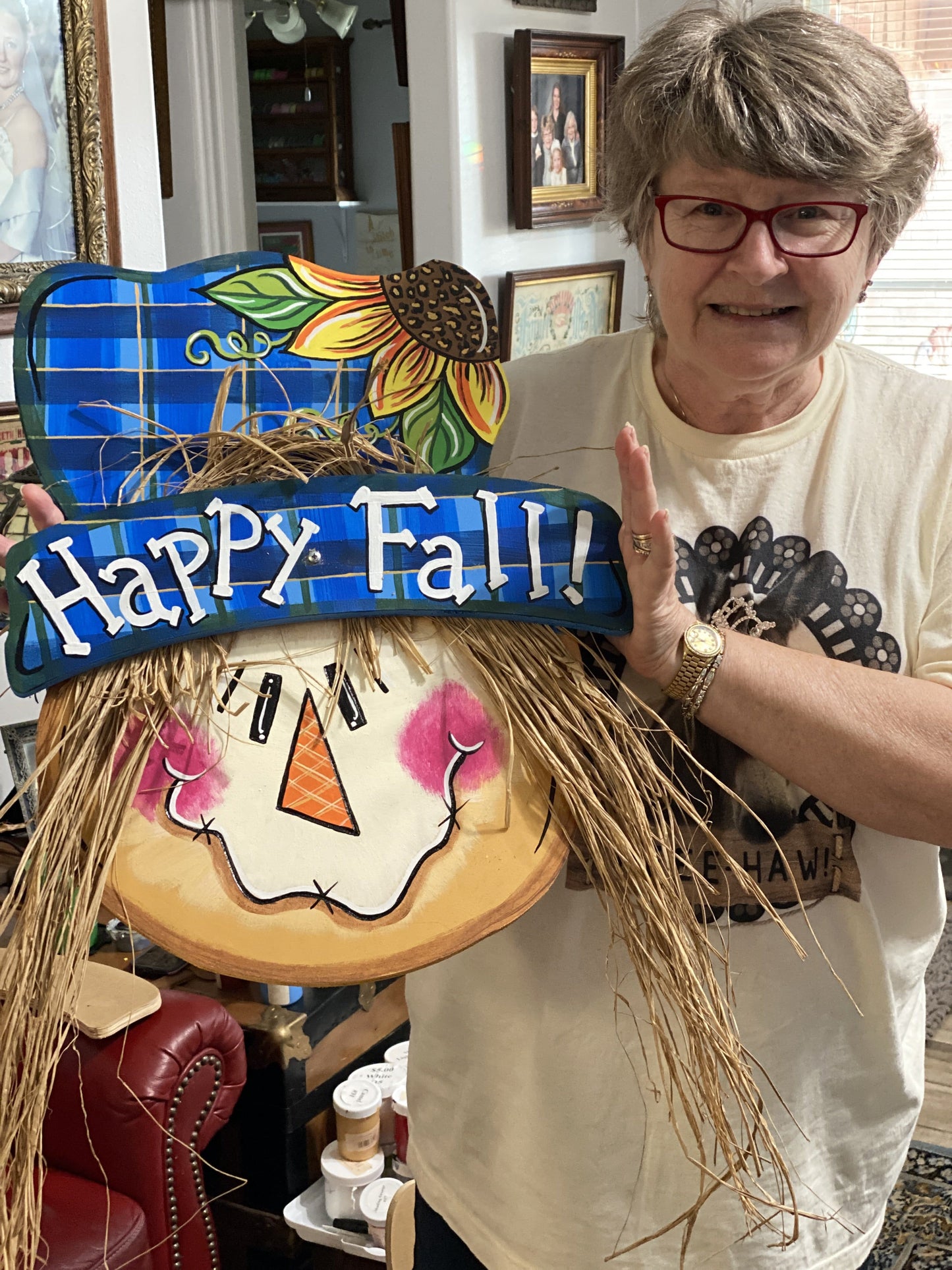 woman holdinh scarecrow with hat painted yard art design