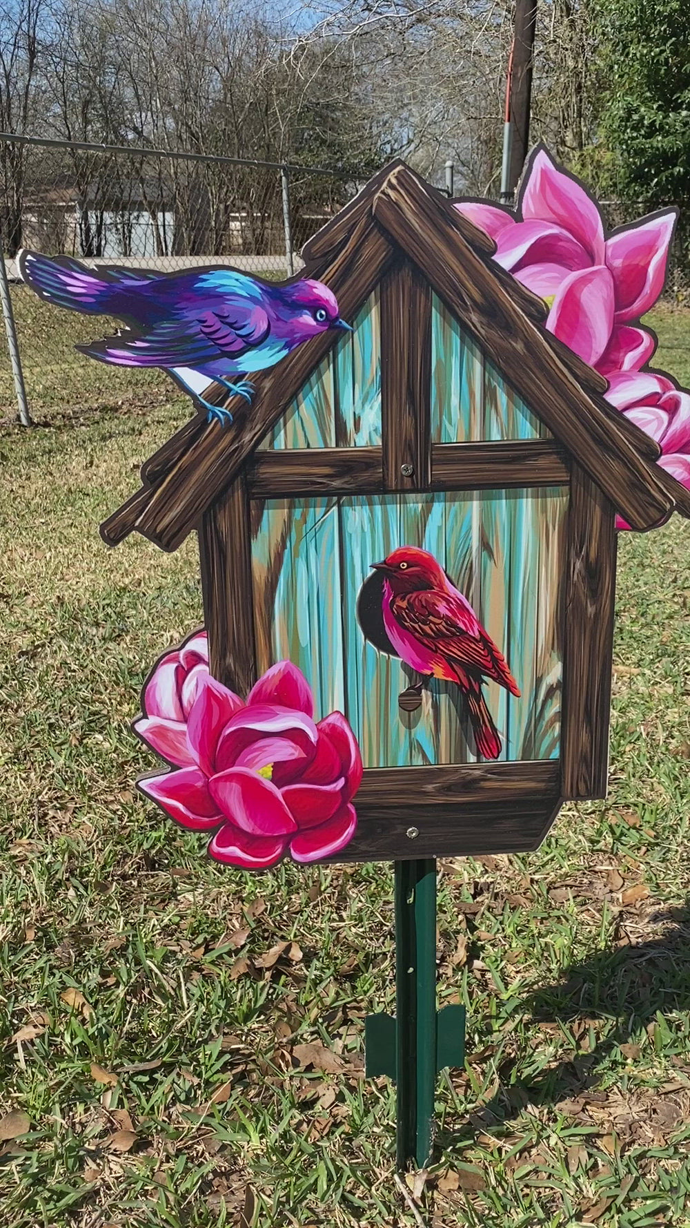 Yard art signs in the shape of a birdhouse with 2 birds and pink flowers on it. Outdoor lawn decor of birds, bees, dragonfly, snails, and more are all available at Yard Art Decor and More. 
