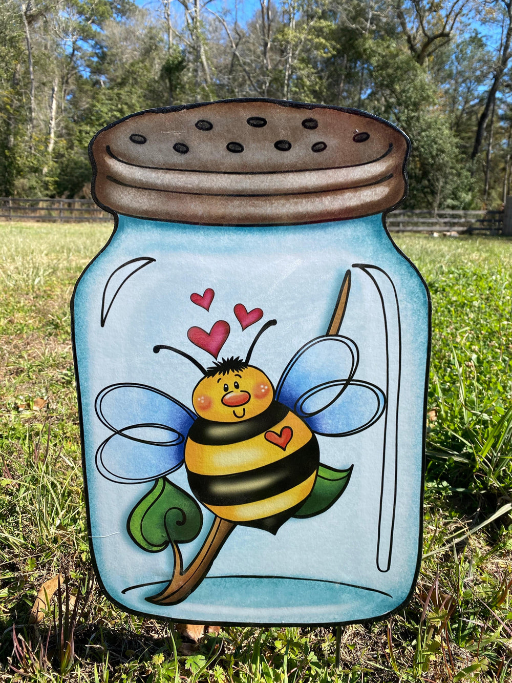Outdoor bumblebee in a jar yard art sign.